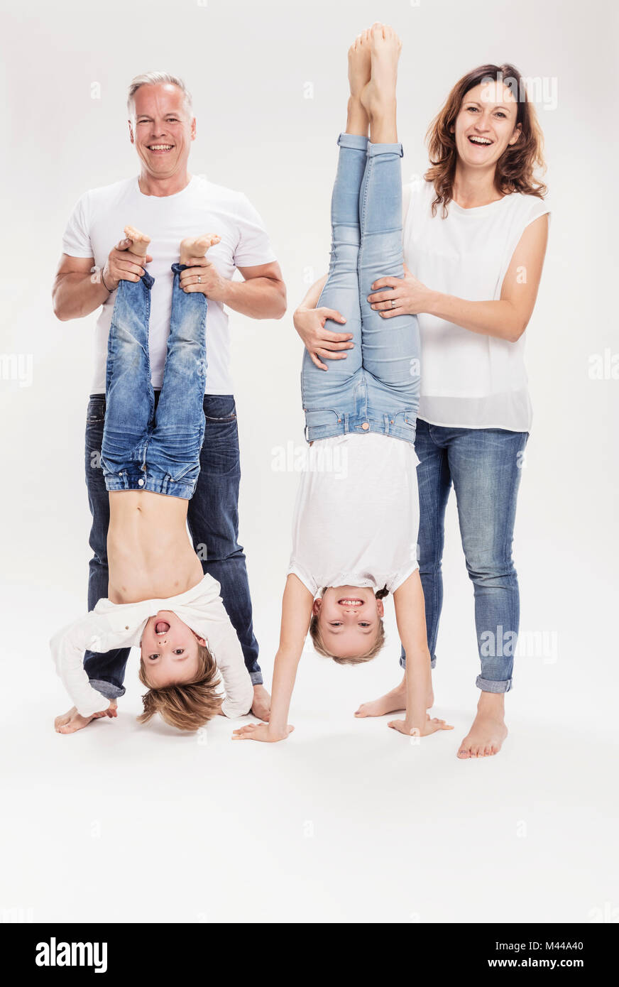 Family portrait with children held upside down Stock Photo
