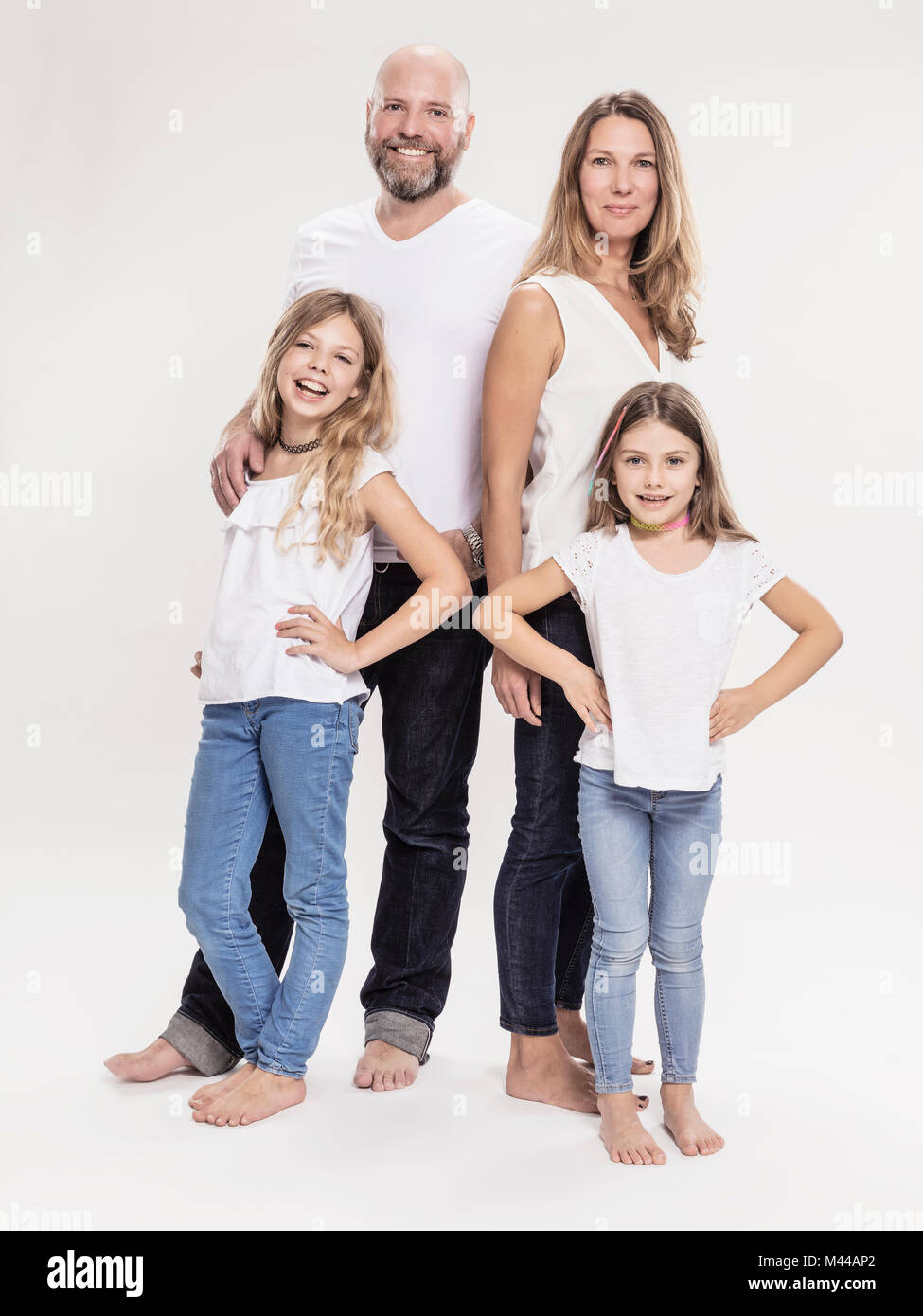 Studio portrait of mature couple with two daughters, full length Stock Photo