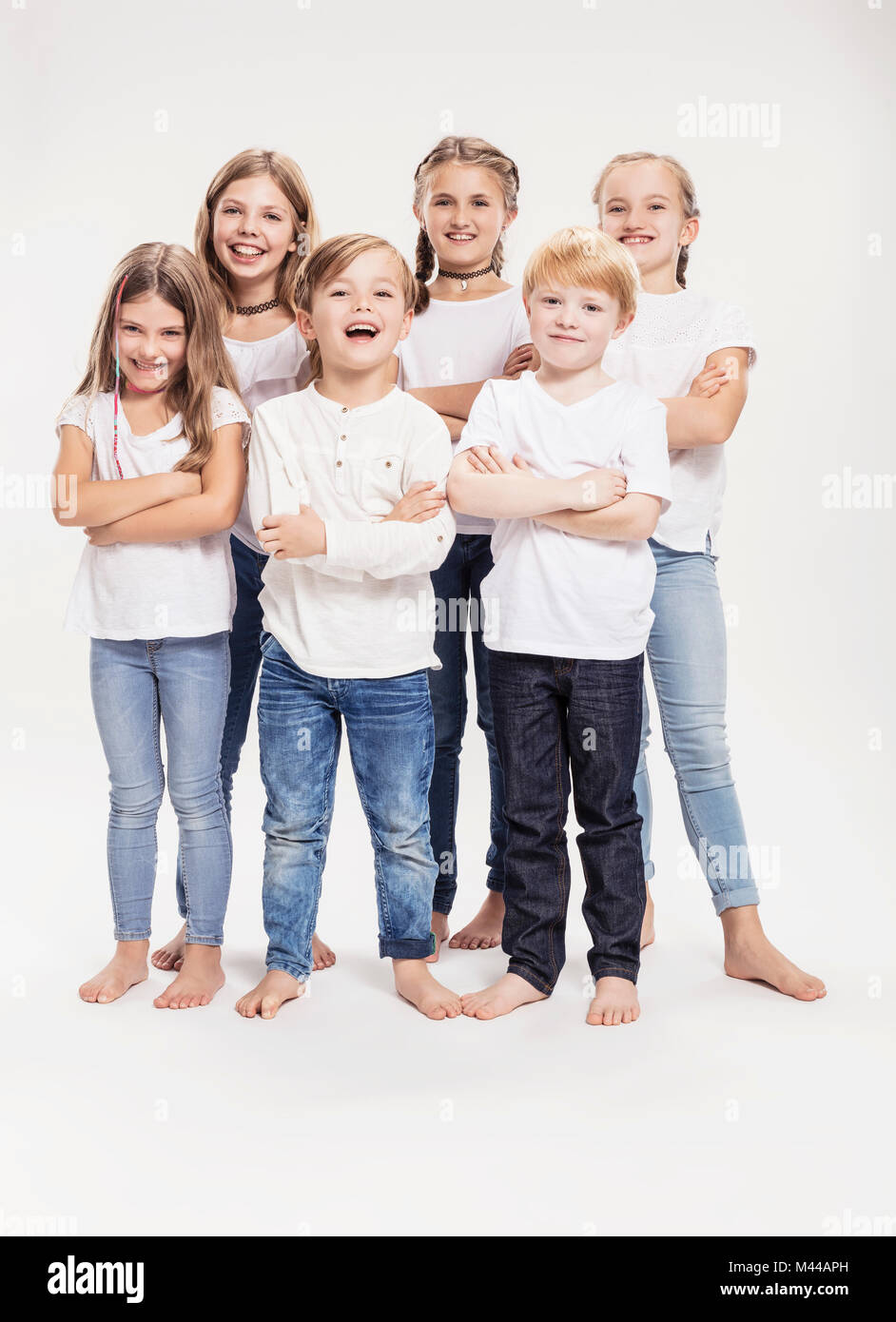 Studio portrait of two boys and four girls with arms folded, full length Stock Photo