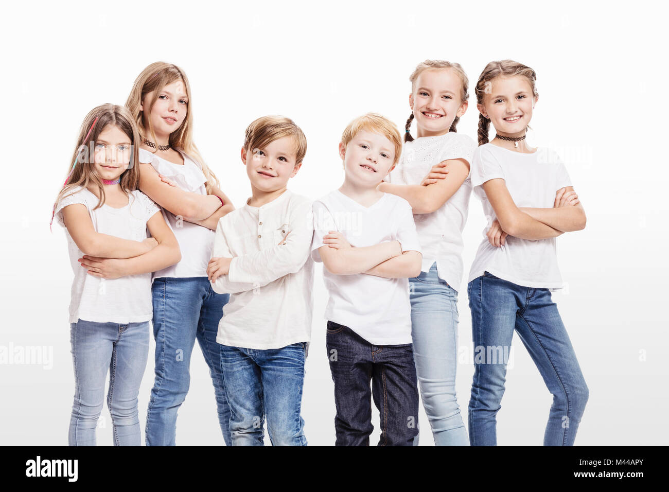 Studio portrait of two boys and four girls posing with arms folded Stock Photo
