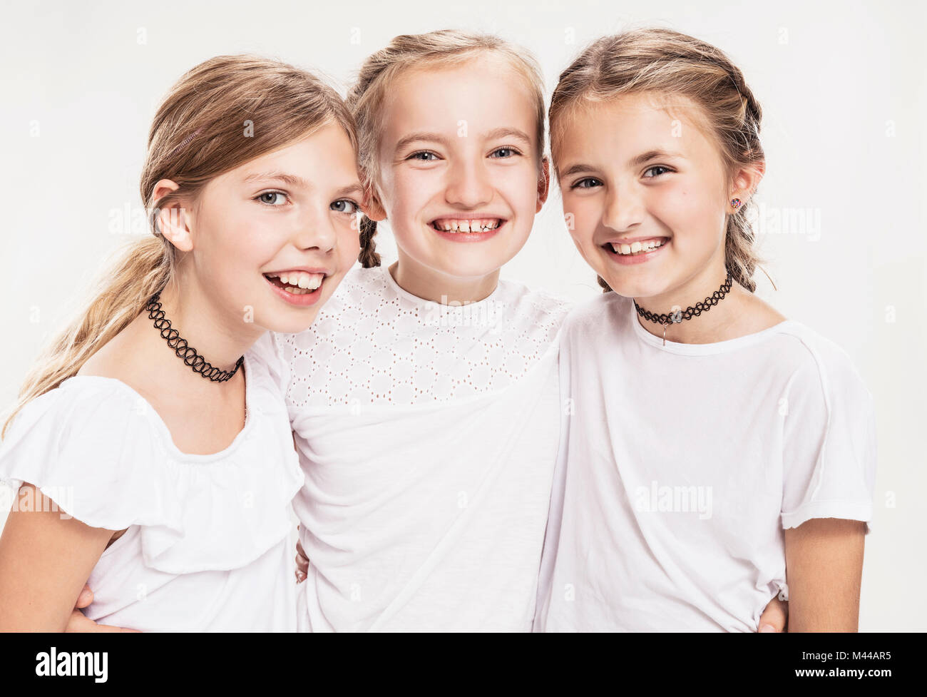 Studio portrait of three girls with blond hair, waist up Stock Photo