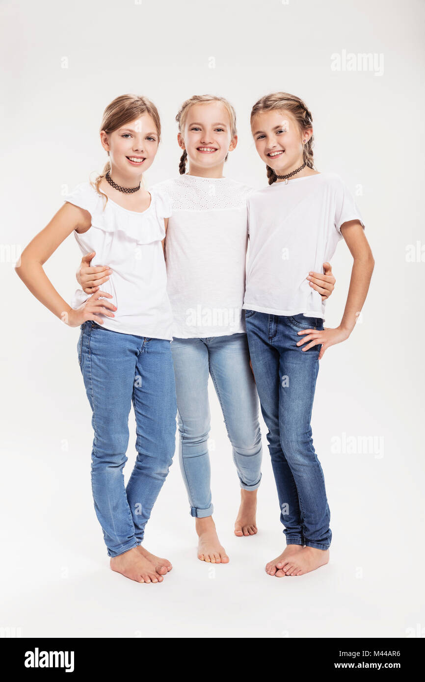 Studio portrait of three girls posing with hands on hips Stock Photo