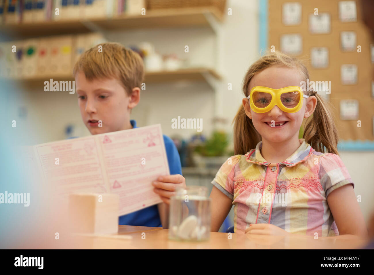 Primary schoolboy and girl doing experiment in classroom Stock Photo