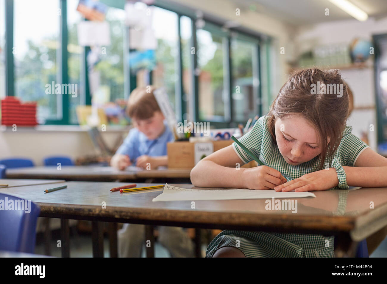 Schoolgirl writing in classroom lesson in primary school Stock Photo