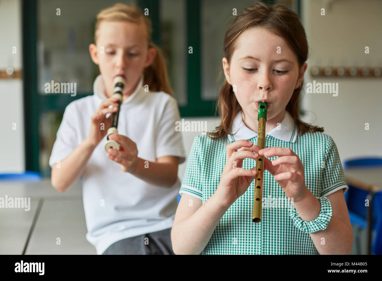 Schoolgirls playing recorders in classroom at primary school Stock Photo