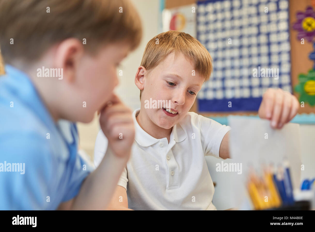 Schoolboys learning together in classroom lesson at primary school Stock Photo
