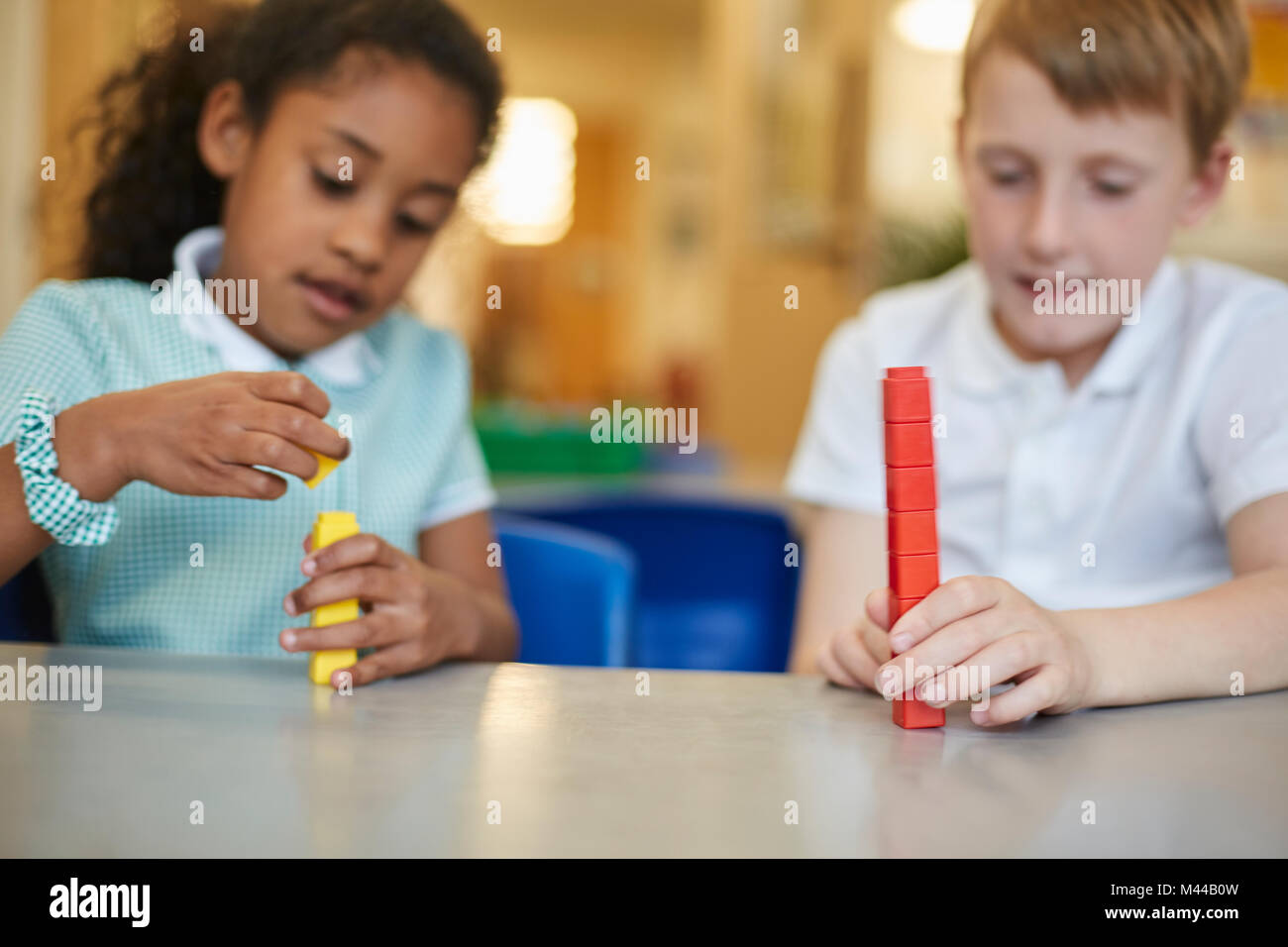 Schoolboy and girl stacking toy blocks in classroom at primary school Stock Photo