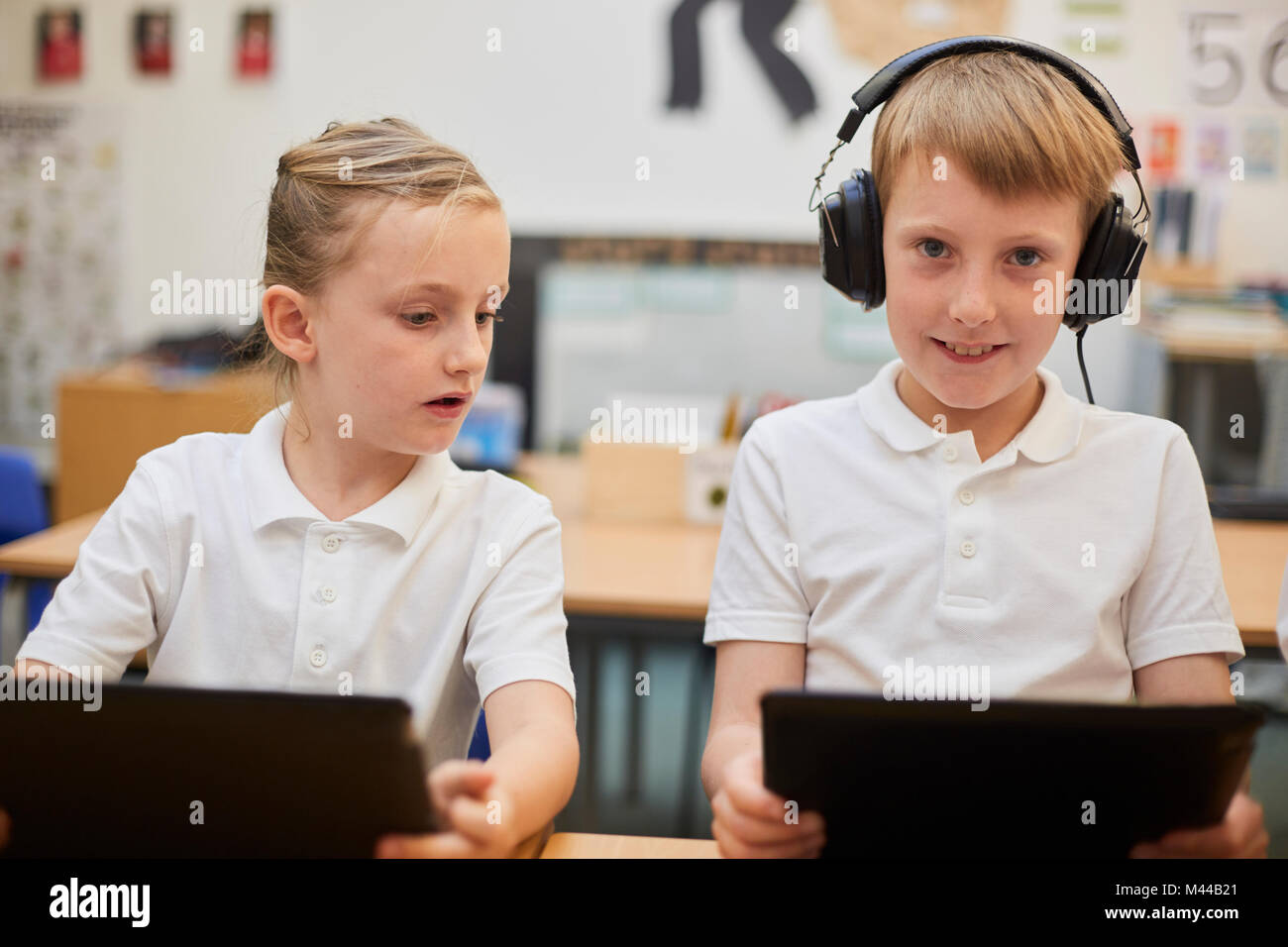 Schoolboy listening to headphones in class at primary school, portrait Stock Photo