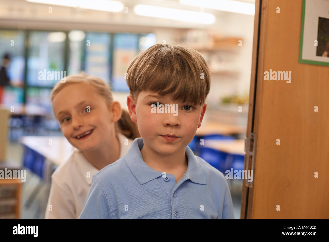 Portrait of schoolboy and girl in classroom at primary school Stock Photo