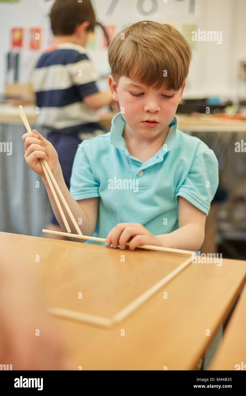 Schoolboy making ball and stick model in classroom at primary school Stock Photo