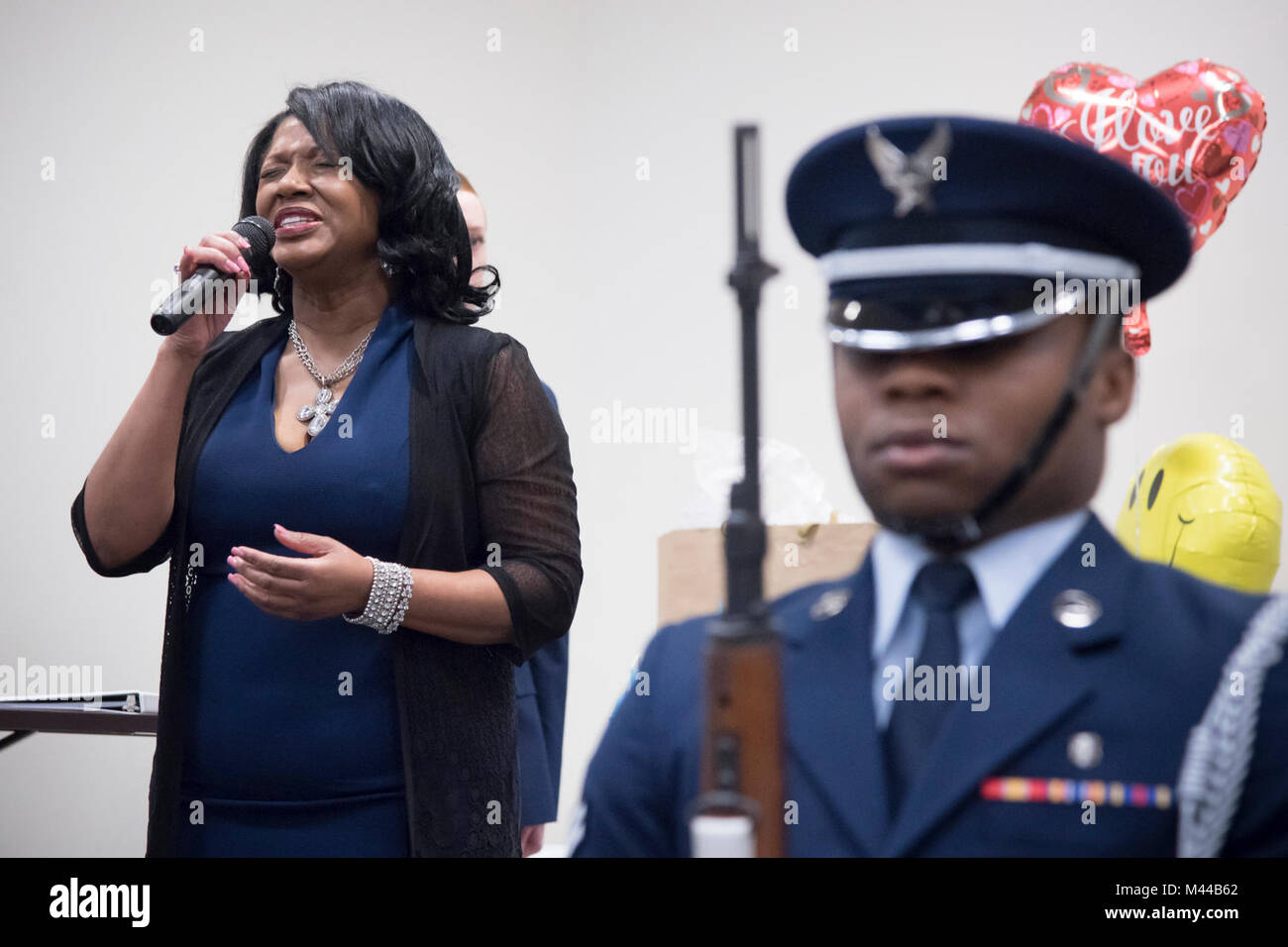 Catherine Brinson sings the National Anthem during a retirement