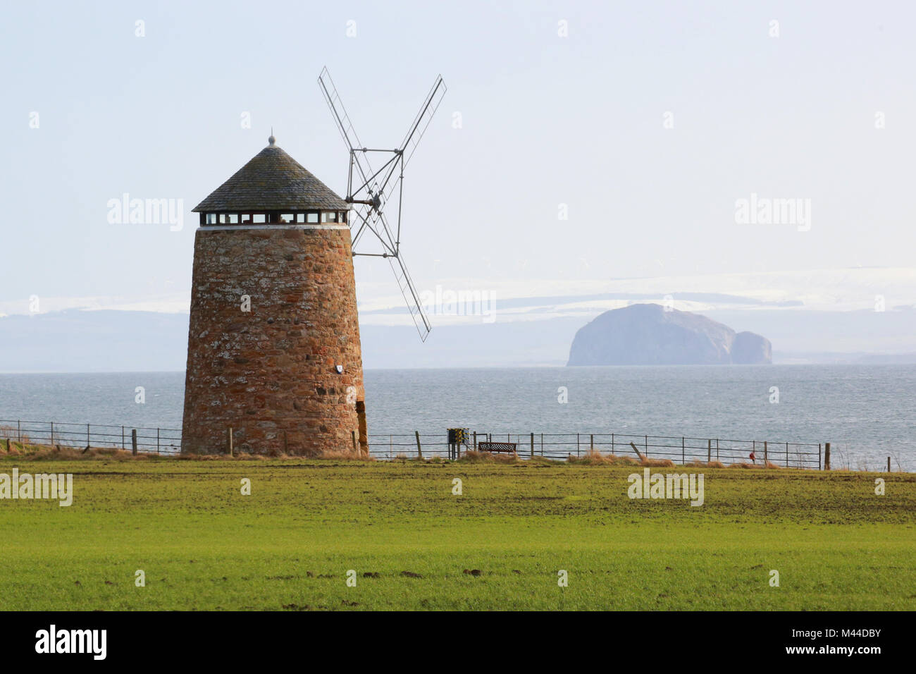 The last remaining windmill just at the edge of St. Monans, Fife. Across the other side of the Firth of Forth is the Bass Rock a moajor bird sanctuary Stock Photo