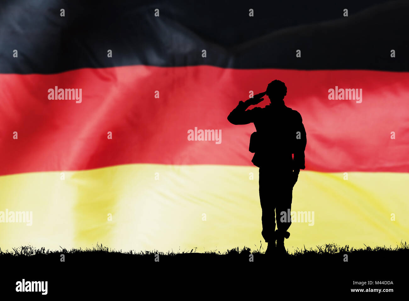 Silhouette Of A Solider Saluting Against The German Flag Stock Photo