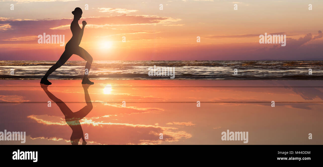 Woman's Silhouette Doing Exercise At Beach With Dramatic Sky During Sunset Stock Photo