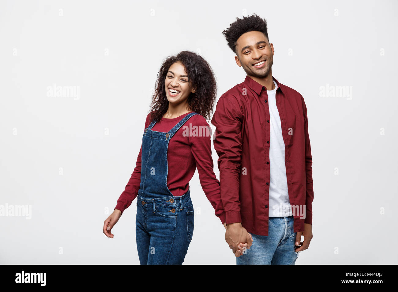 happy african american couple holding hands and looking back isolated ...