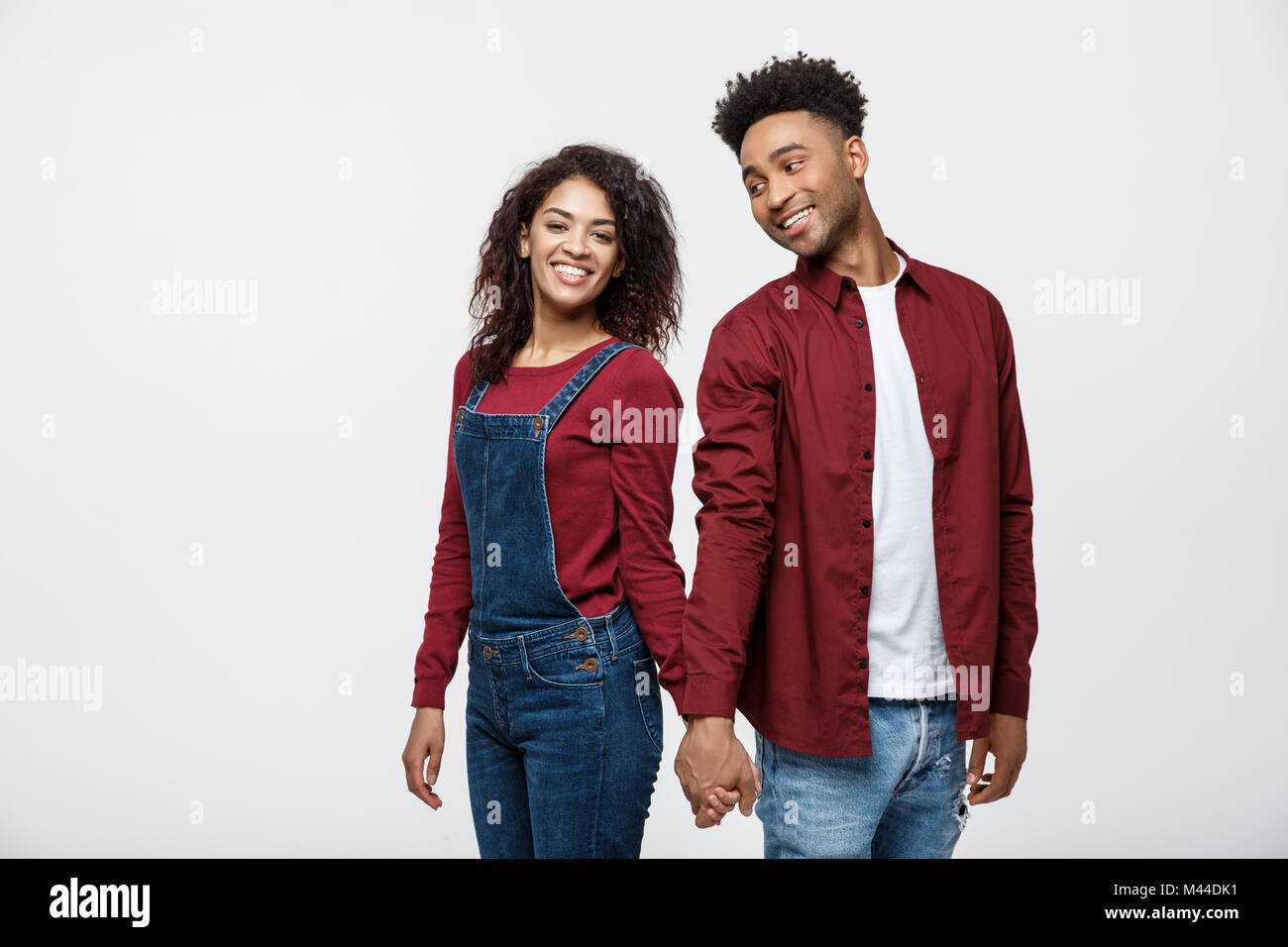 happy african american couple holding hands and looking back isolated ...