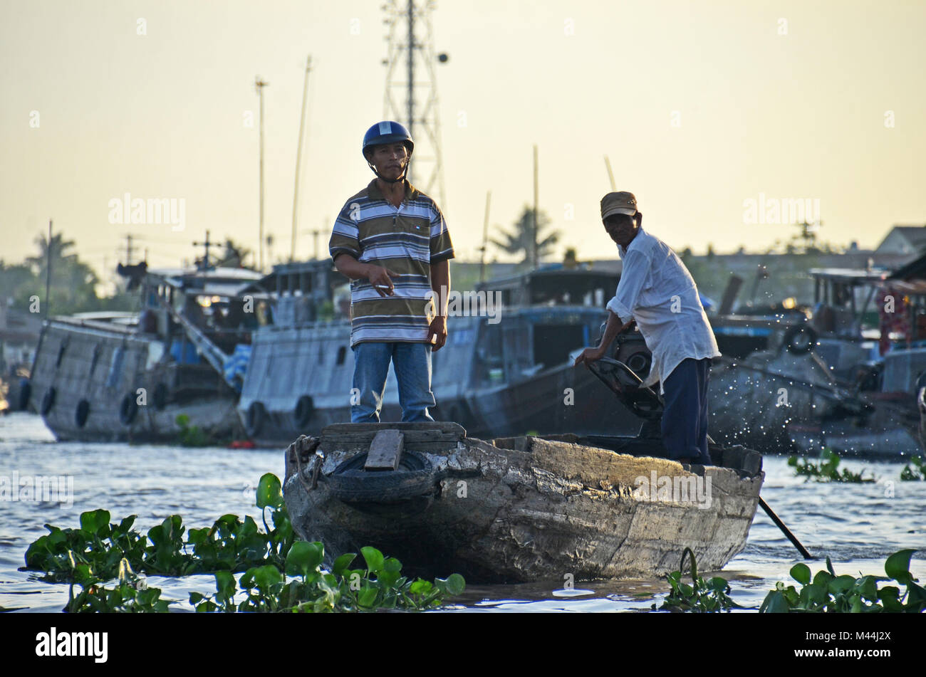 A man smokes a cigarette while standing in the prow of a boat in Cai ...