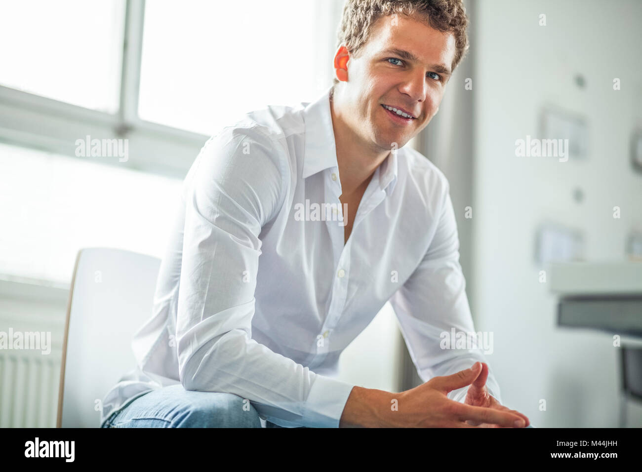 Portrait of confident young businessman sitting in office Stock Photo