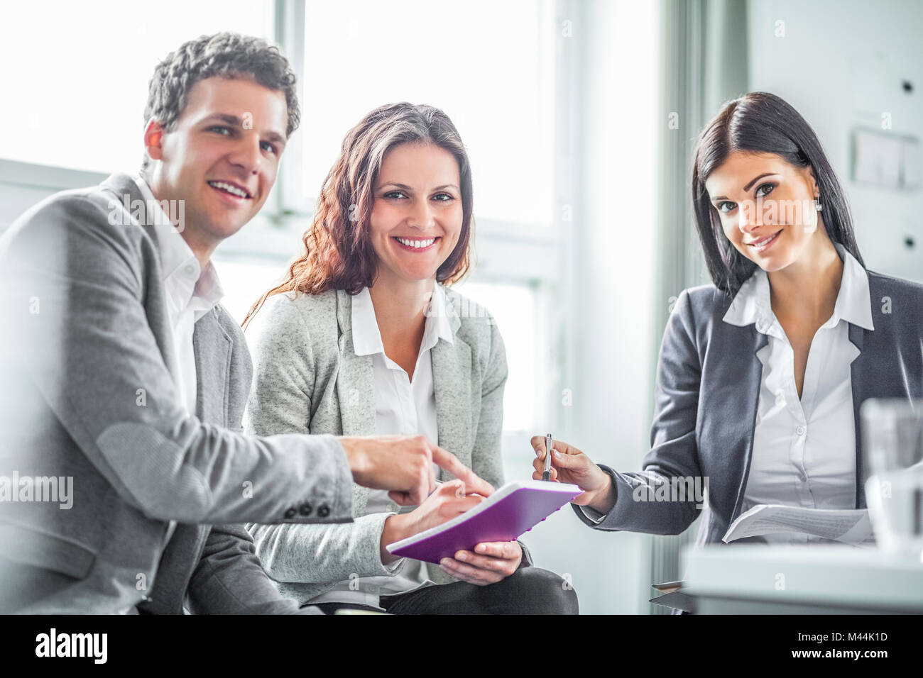 Portrait of smiling business people discussing in office Stock Photo ...