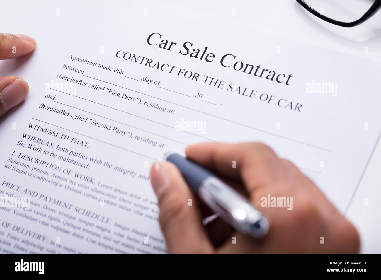 Close-up Of A Person's Hand Filling Car Sale Contract Form Stock Photo