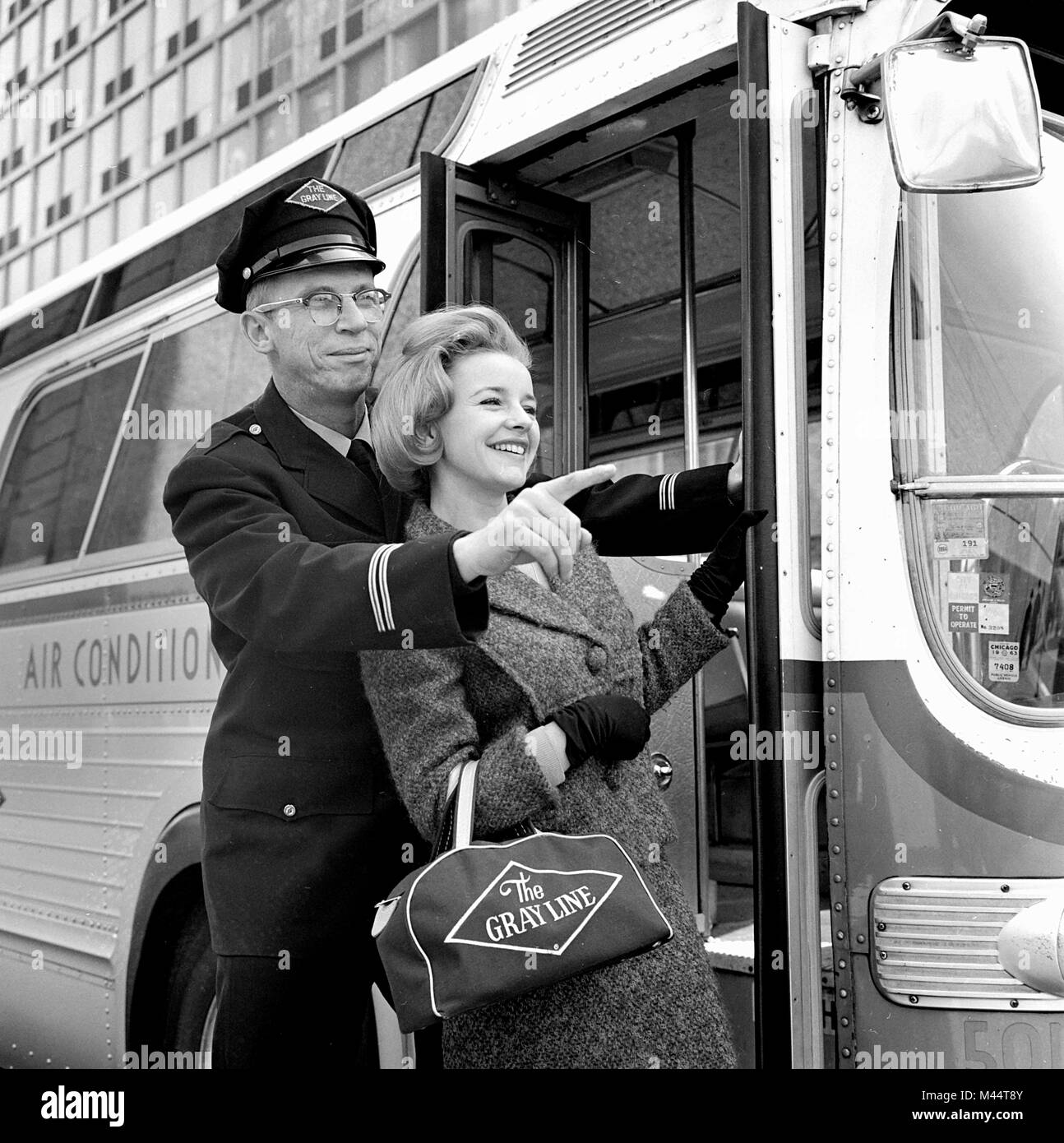 Extremely helpful bus driver gives personal close-up attention to a female passenger in Chicago, ca. 1963. Stock Photo