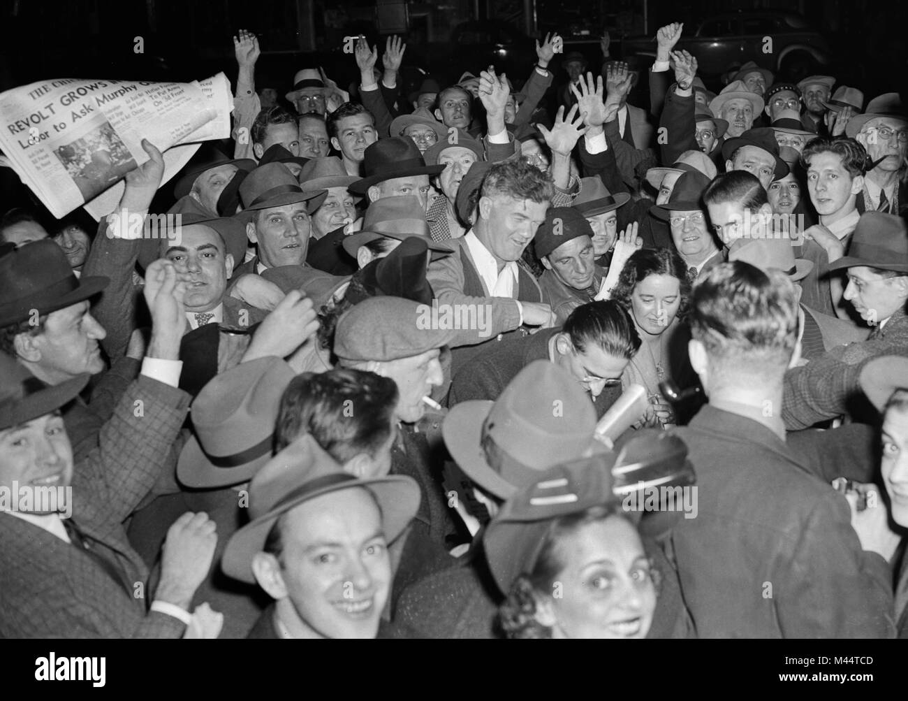 Street crowd in Chicago rushes to buy a newspaper for news of World War II, ca. 1944. Stock Photo
