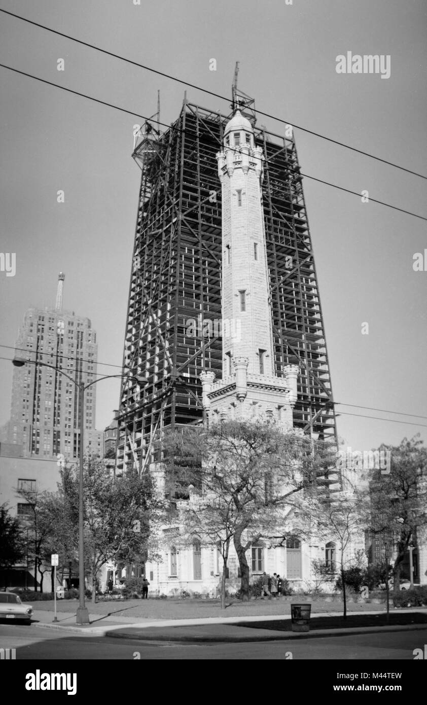 The John Hancock Center rises behind the Water Tower along Michigan Avenue in Chicago, ca. 1967. Stock Photo