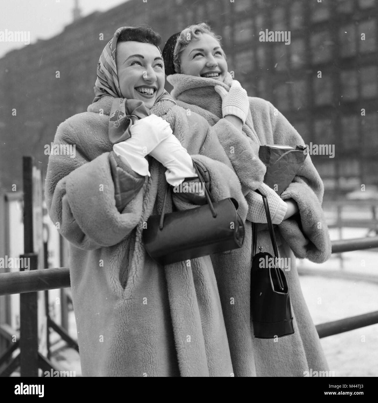Two fashionable young women bundle up against the cold Chicago winter weather, ca. 1956. Stock Photo