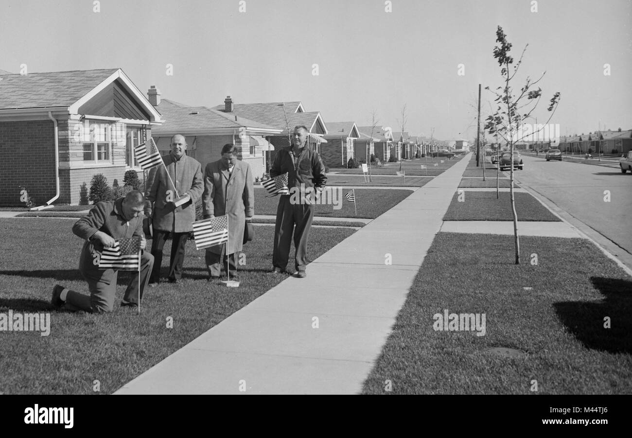 South suburban Chicago men plant American flags in the front yards of their homes, ca. 1958. Stock Photo