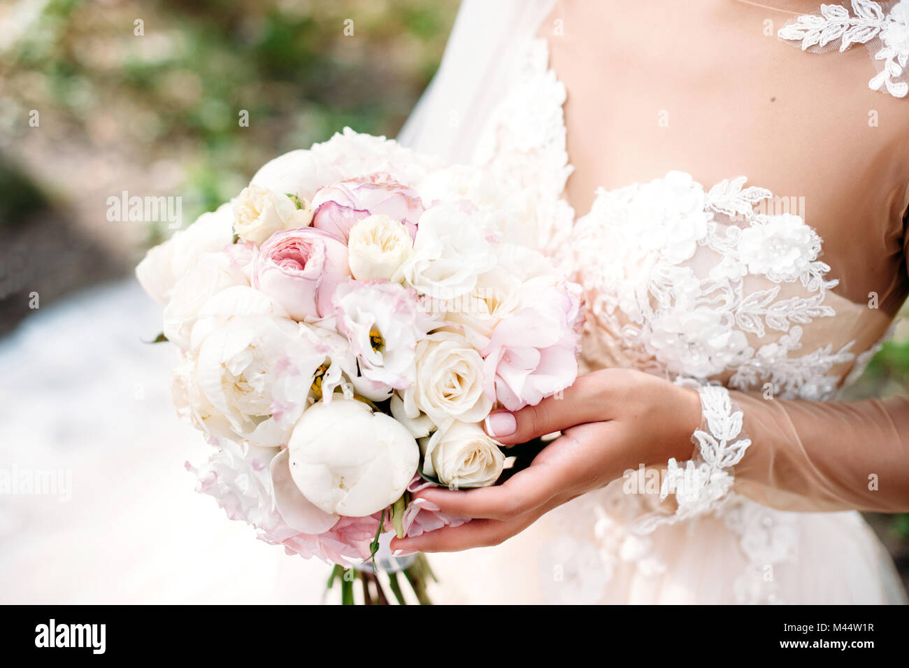 Bride holding wedding peony bouquet in your hands. White and pink flowers. Close-up Stock Photo