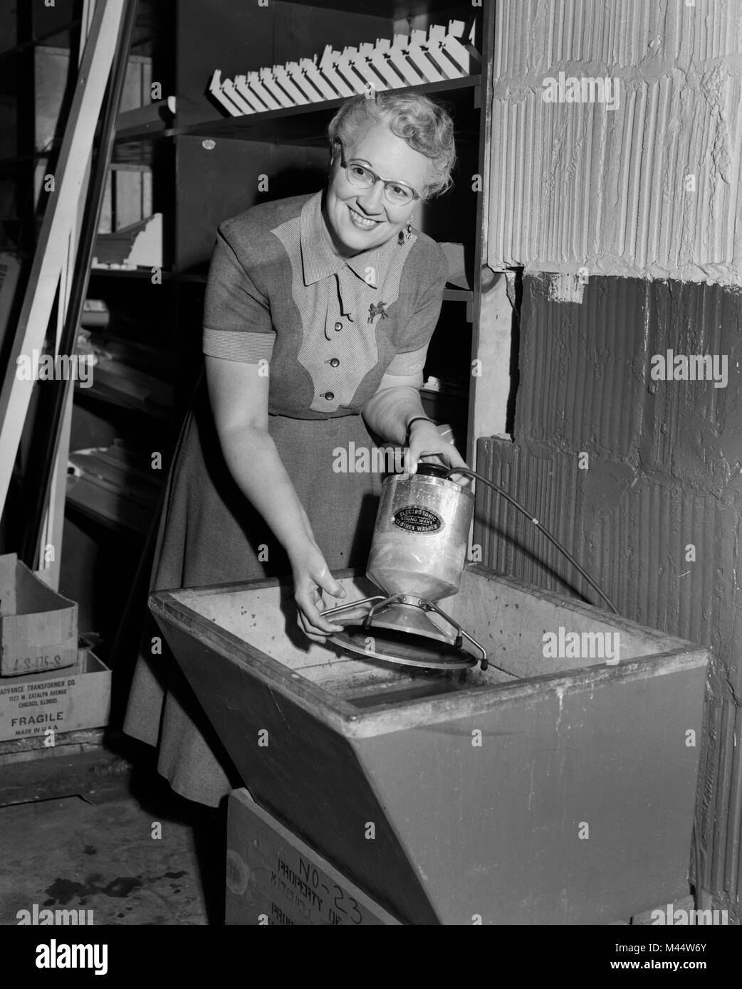 Woman uses an electrosonic sound wave clothes washer, ca. 1962. Stock Photo
