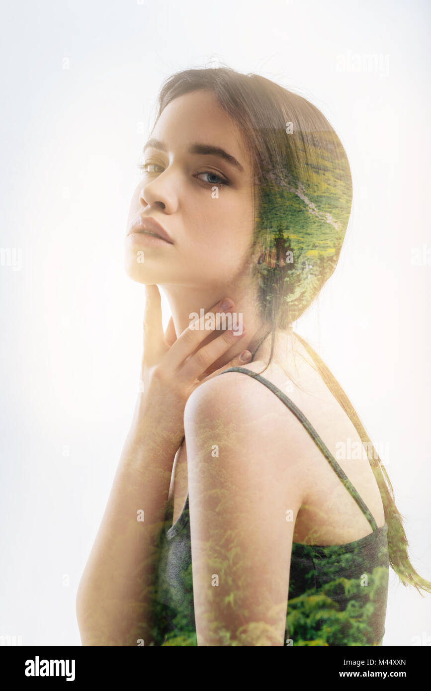 Pretty woman sitting round shouldered and touching her neck Stock Photo ...