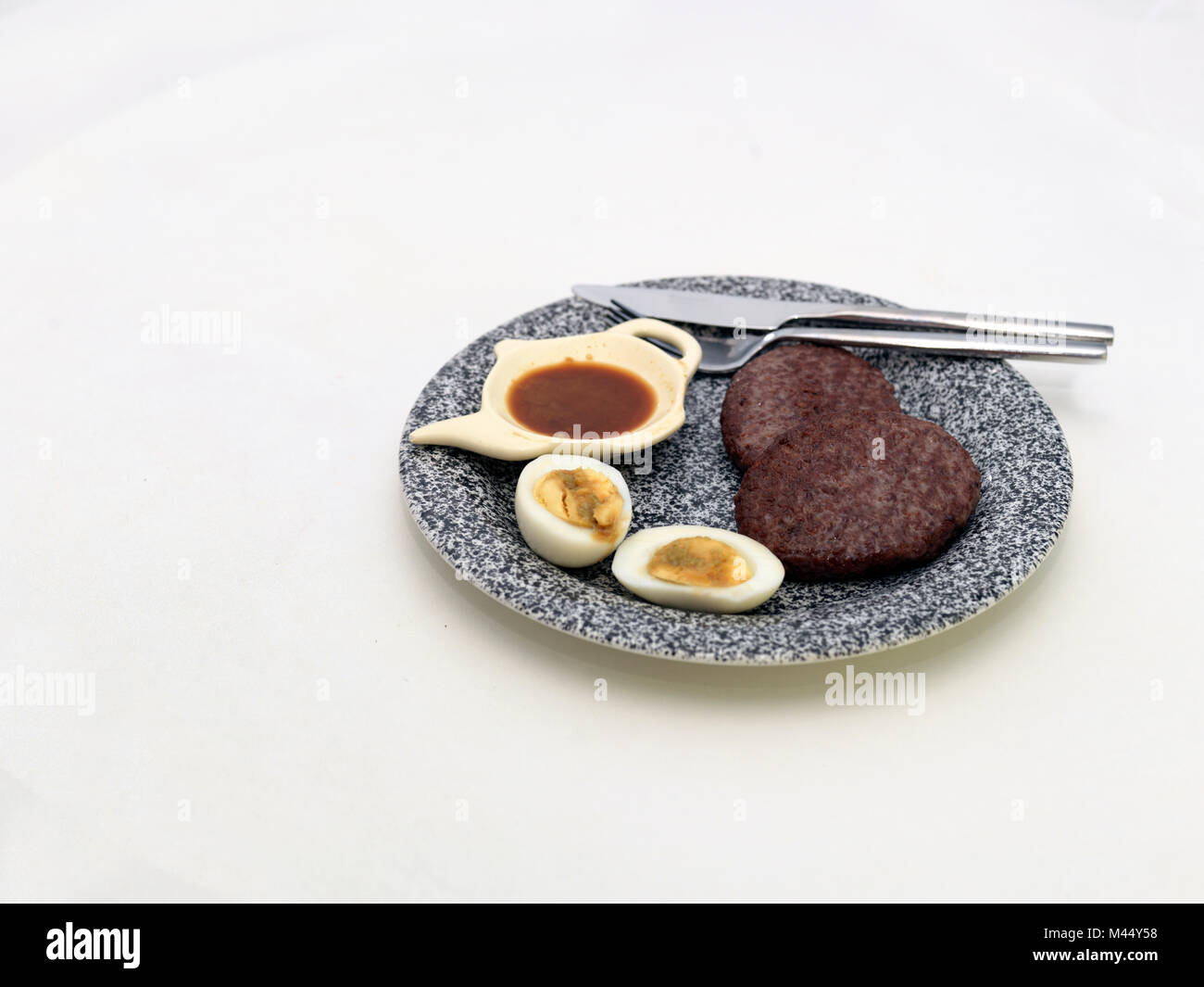 Pan fried beef cutlets, sauce and eggs. White table top background