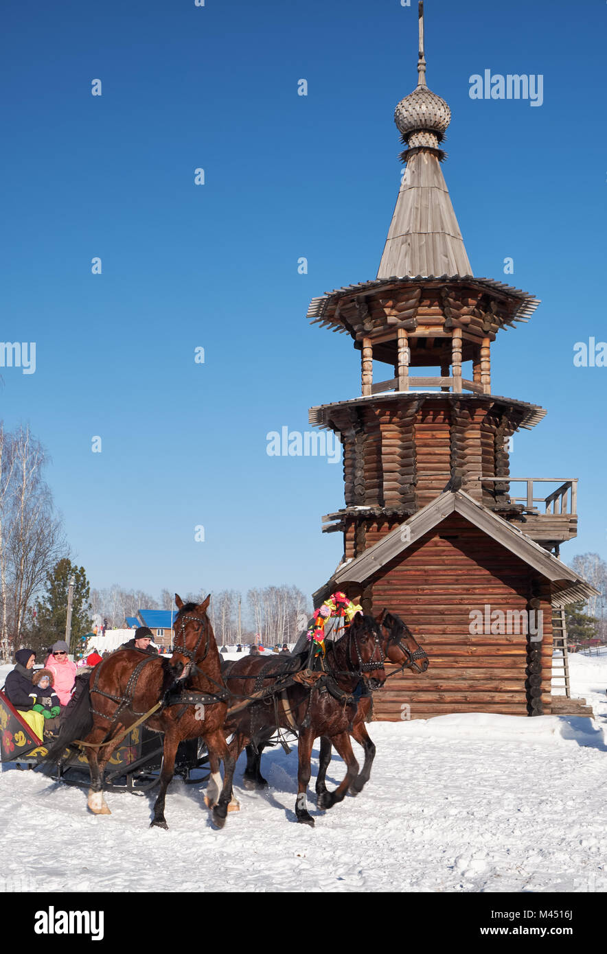 NOVOSIBIRSK, RUSSIA - JANUARY 11, 2018: Troika of horses harnessed to a sleigh.  Slavonic folk  winter festivities Shrovetide. The Church of the Savio Stock Photo