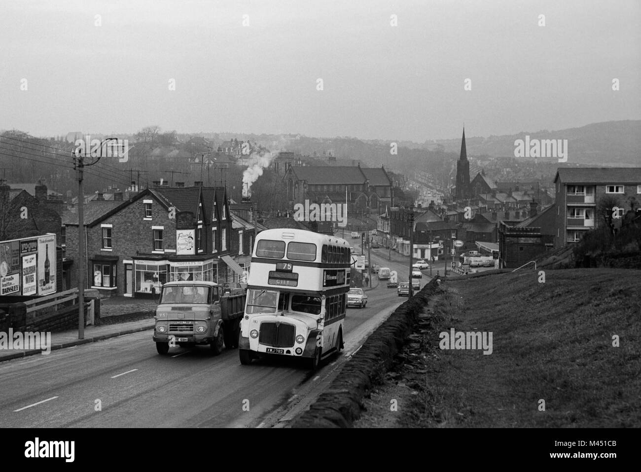 Number 75 Sheffield Corporation AEC Bus XWJ 782 climbs a hill on its way to Sheffield city centre whilst being overtaken by a Commer Truck. Stock Photo