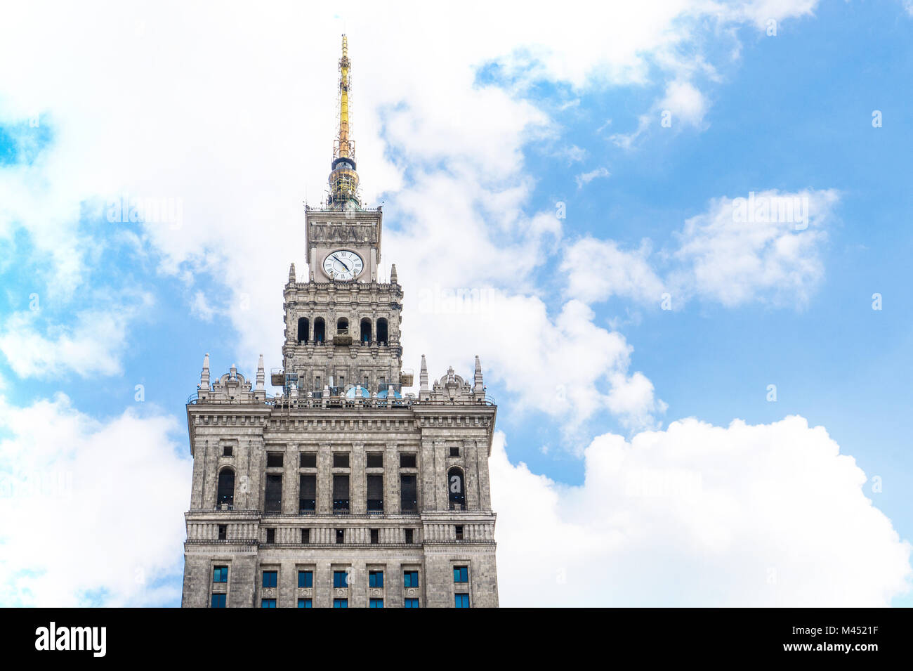 The highest top of the Palace of Culture and Science in Warsaw Poland against partly cloudy sky on a summer day. Stock Photo