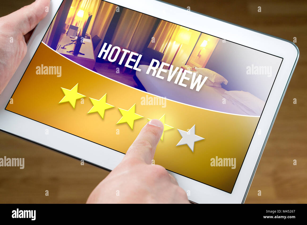 Good hotel review. Satisfied and happy customer giving great rating with tablet on an imaginary criticism site, application or website. 4/5 stars. Stock Photo