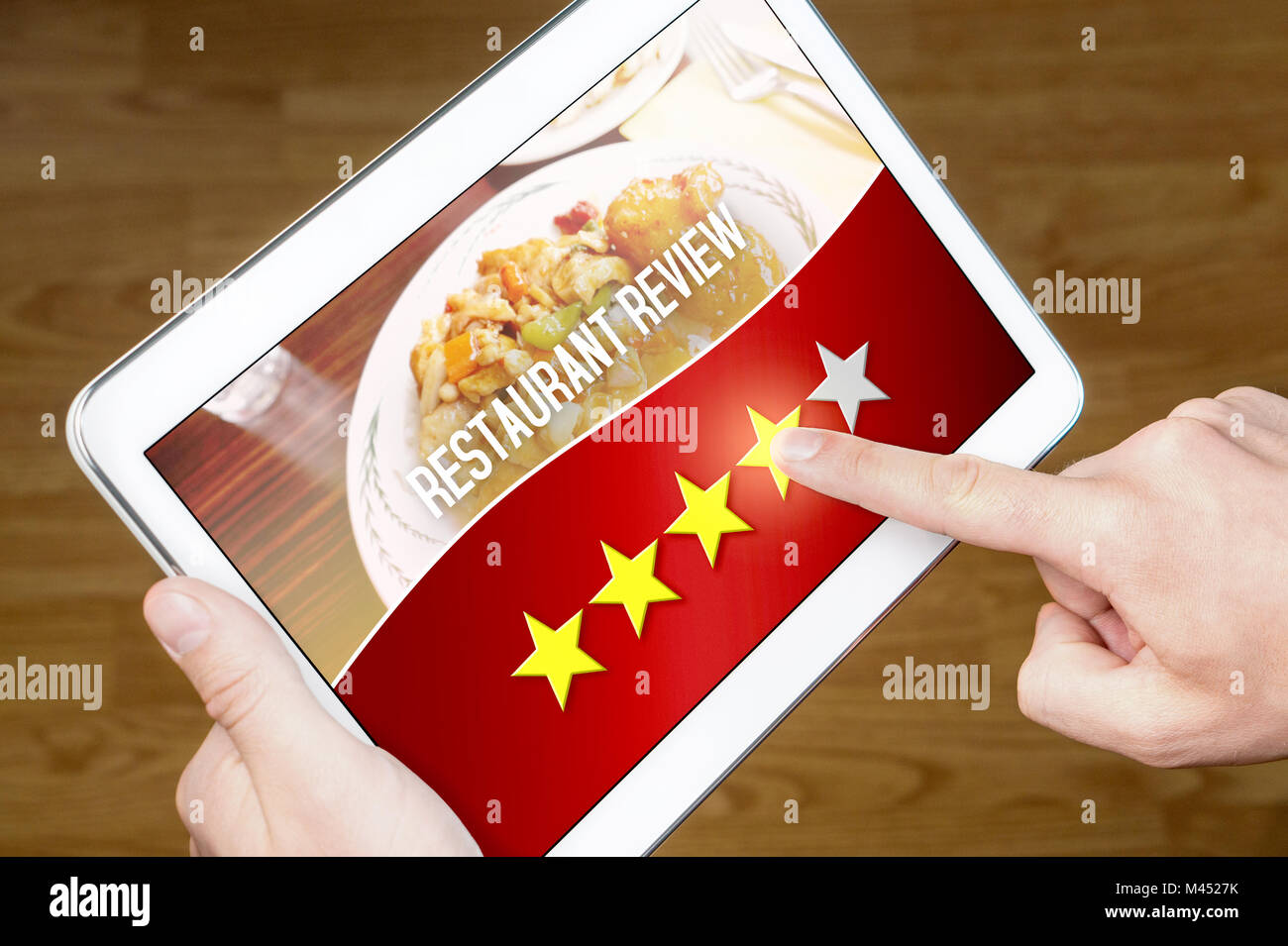 Good restaurant review. Satisfied and happy customer giving great rating with tablet on an imaginary criticism site, application or website. 4/5 stars Stock Photo