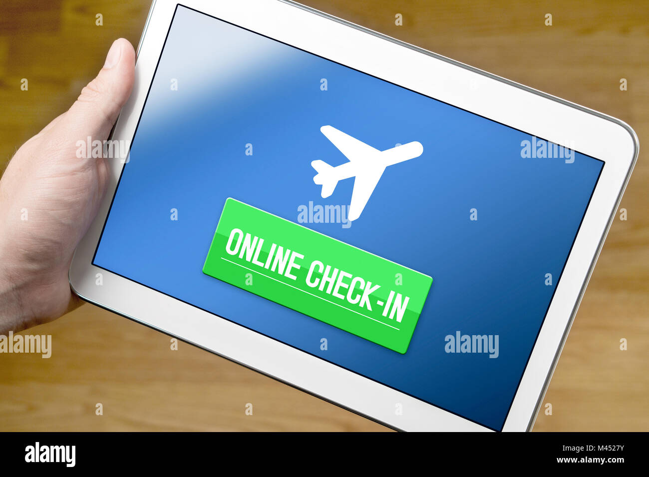 Man checking in to flight with tablet on the internet. Online check in with mobile device at home. Web self service provided by airline. Stock Photo