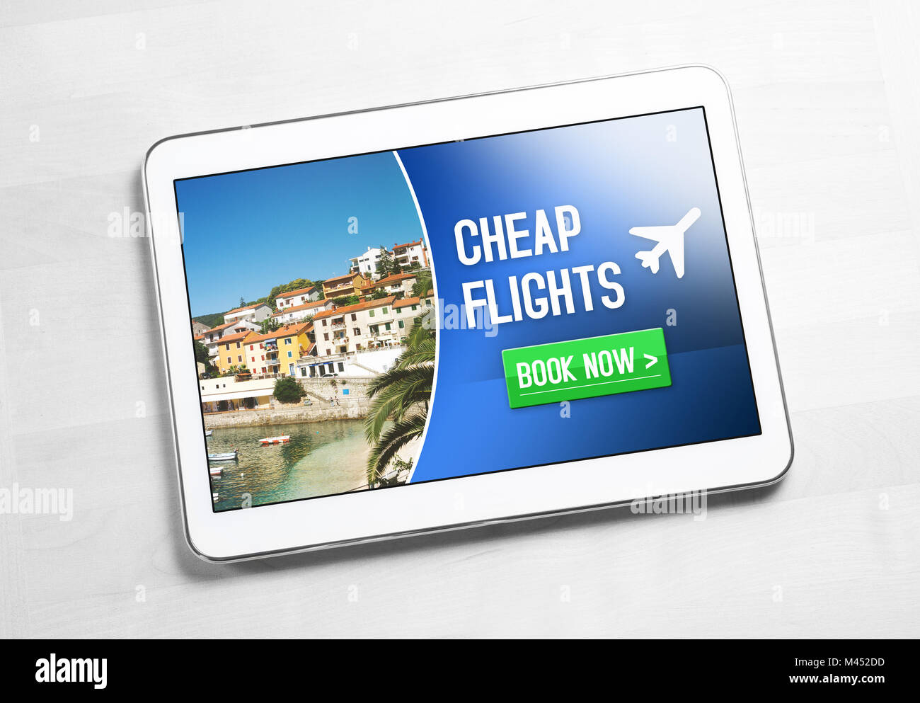 Cheap flights for sale on internet. Top view to tablet on wooden table with affordable and inexpensive vacation offer on screen. Stock Photo