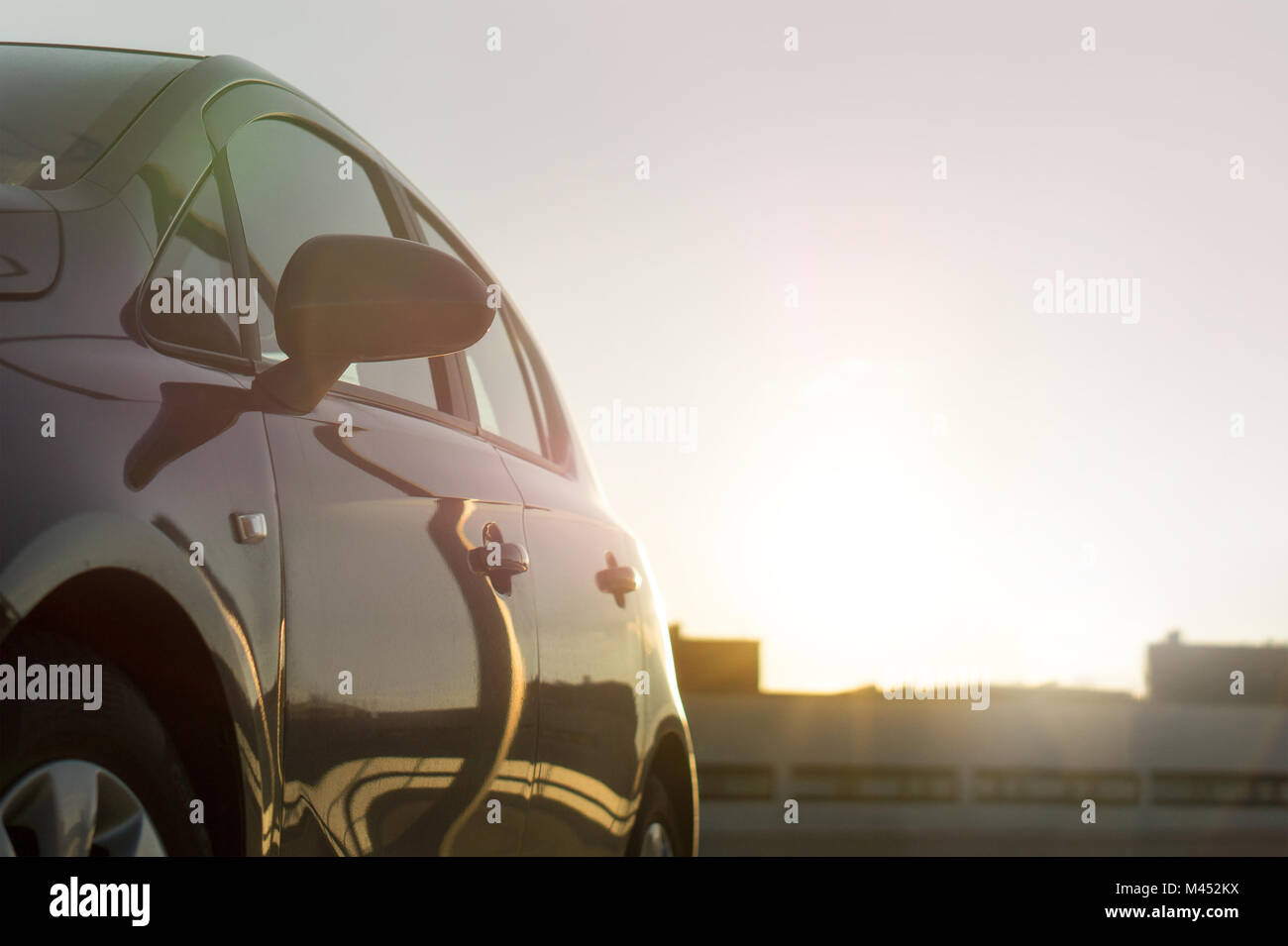 Summer time sunset or sunrise cruising in urban city. Car background or template with copy space. Modern vehicle driving in sun light, close view. Stock Photo