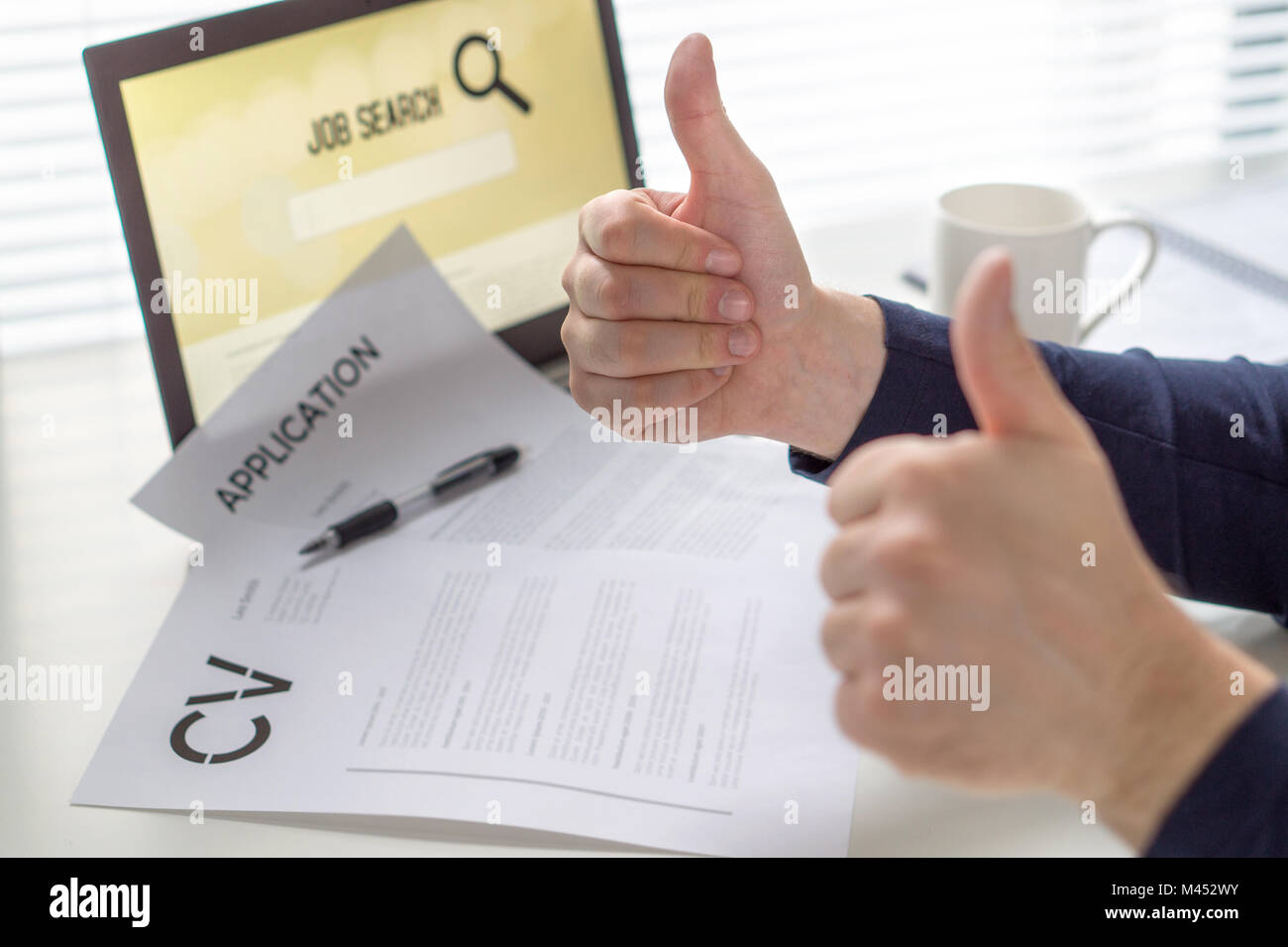 Thumbs up for job search. Applicant with positive attitude. Happy job seeker showing two hand gestures. Cheerful man pleased with finding work. Stock Photo