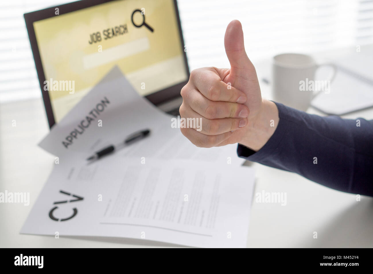 Thumbs up for job search. Applicant with positive attitude. Happy jobseeker. Cheerful man pleased with finding work. Hired or motivated job seeking. Stock Photo