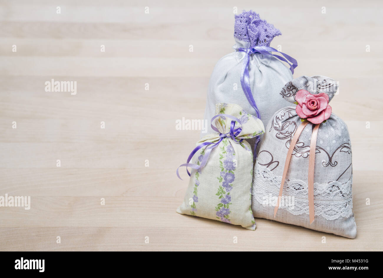 Three lavender scent pouches on wooden board or table. Scented sachets on wood with copy space. Fragrance bags for fresh home. Decoration. Stock Photo
