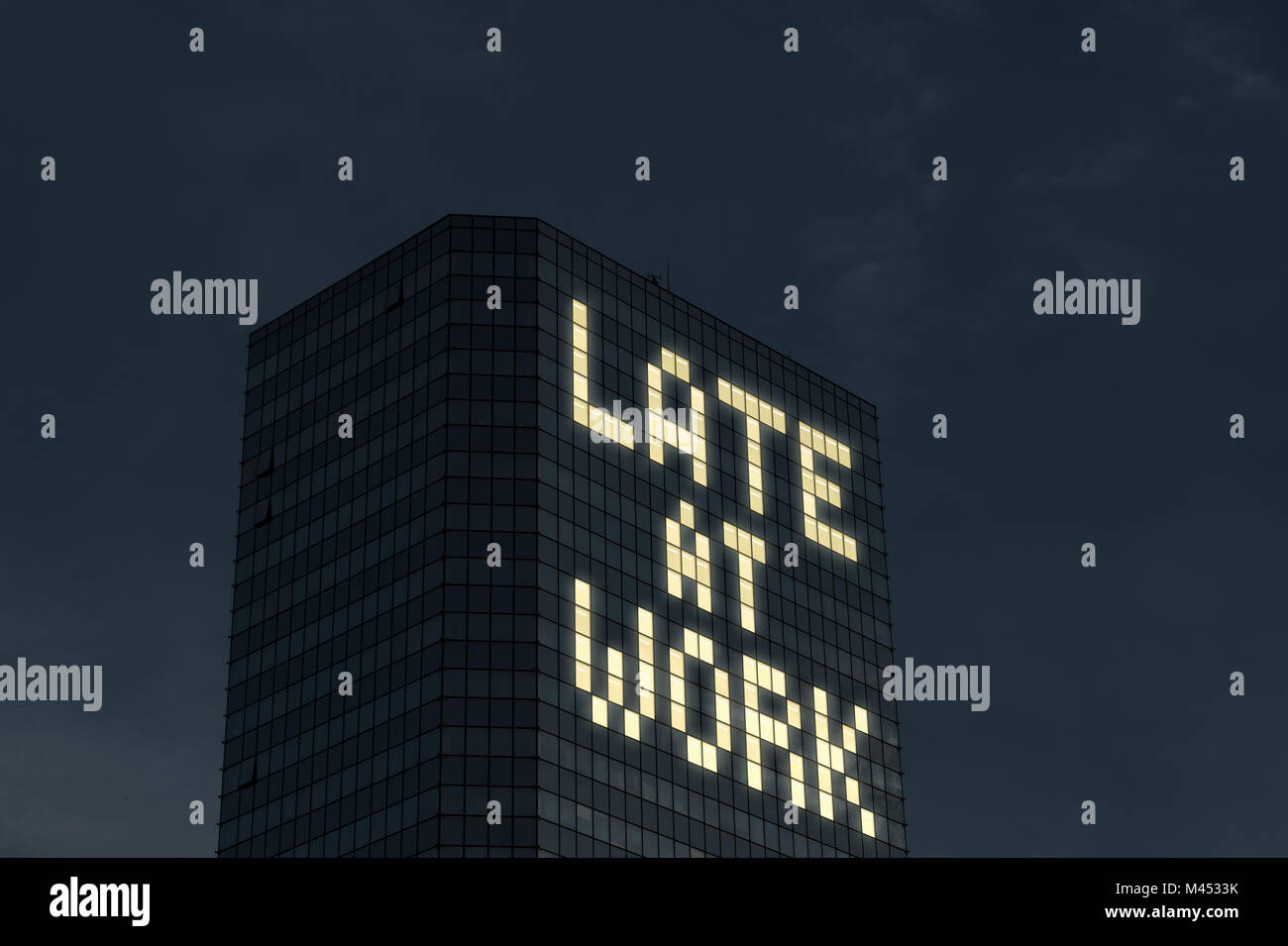 Late at work concept. Working overtime and extra hours. Tired, stressed from too much things to do at job. Text made by office building window light. Stock Photo
