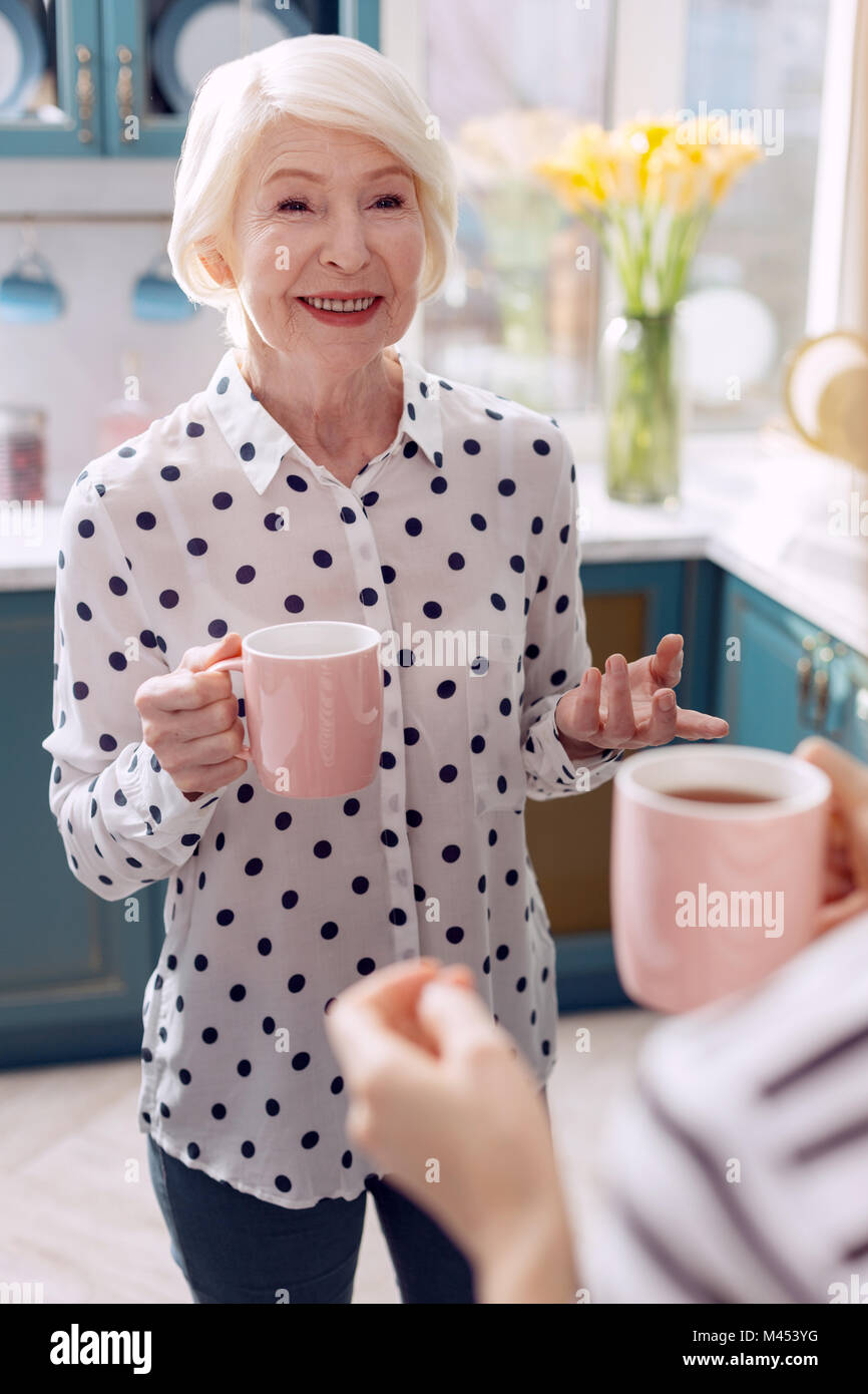 Elderly woman drinking coffee in kitchen and talking Stock Photo Alamy