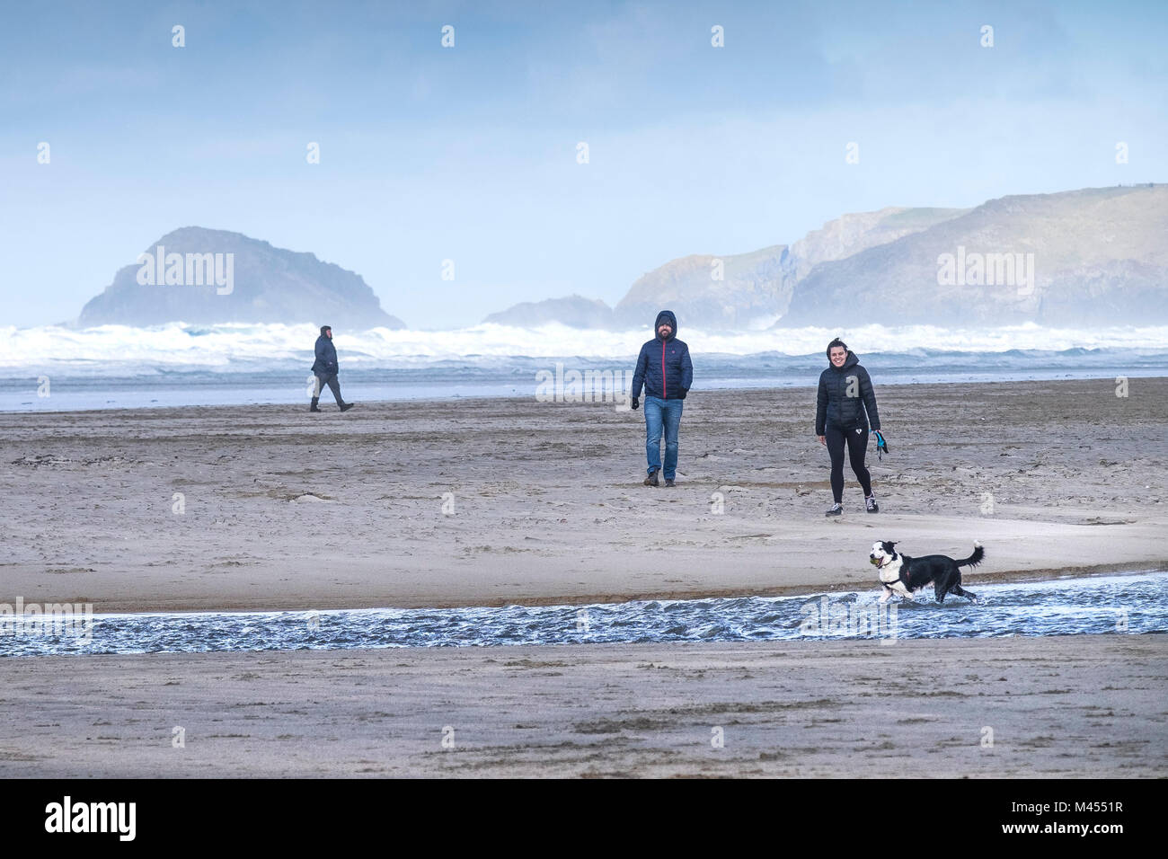 People walking their dog on Perranporth Beach in Cornwall. Stock Photo