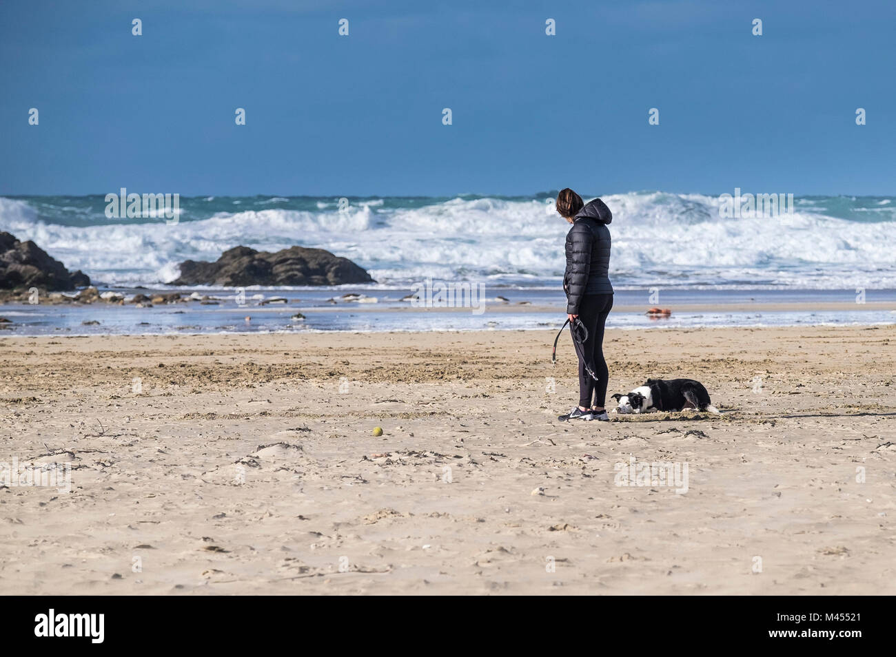 A dog owner and her dog Perranporth Beach in Cornwall UK. Stock Photo