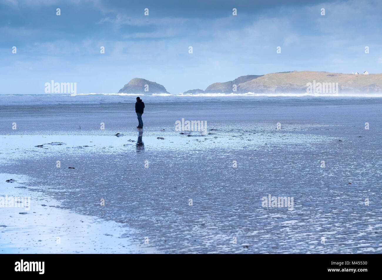A man standing on Perranporth Beach in Cornwall UK. Stock Photo