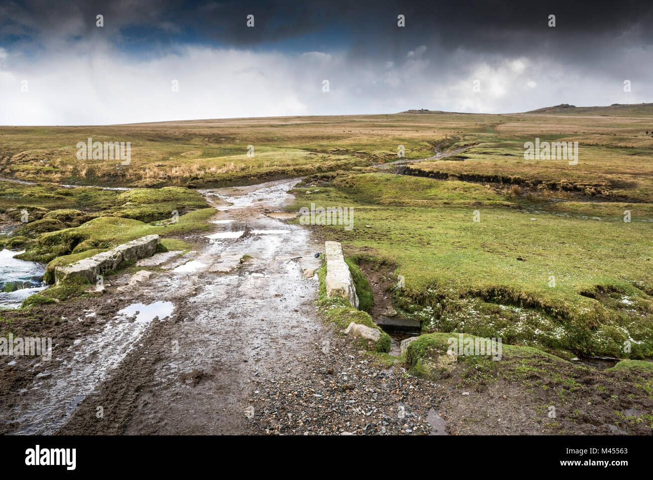 A muddy track on a small stone bridge over a stream at Rough Tor on Bodmin Moor in Cornwall. Stock Photo